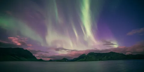 Leichte grüne und pinke Nordlichter über Island