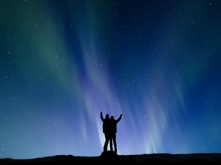 Personen unter den Nordlichter in Island