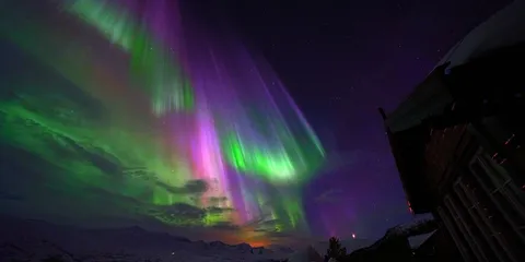 Grüne und pinke Nordlichter über Norwegen